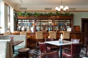 Northolt维特斯潘格林伍德酒店的一间带桌椅的餐厅和一间图书馆