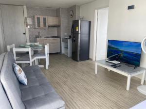 卡塔赫纳FRAGATA STYLE 2的带沙发和电视的客厅以及厨房。