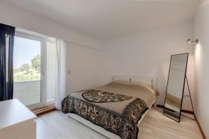 里斯本Spacious 3-bedroom condo in Lisbon的一间卧室配有镜子、一张床和一个窗户