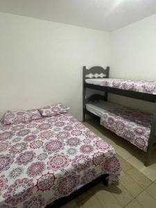 拉巴拉德纳圣米格尔Casa de Praia na Barra de São Miguel - AL的一间卧室配有两张床和一张双层床。
