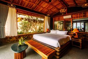 富国Ocean Bay Phu Quoc Resort and Spa的一间卧室配有一张床、一张长凳和一个窗户。