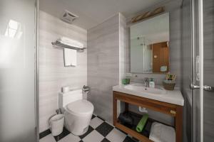 安平区安平肯辛顿旅店的一间带卫生间、水槽和镜子的浴室
