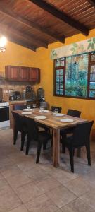 巴尼奥斯"Casa Verde" en Baños de Agua Santa con vista al volcán Tungurahua的厨房里配有一张带椅子的大型木桌