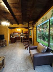 巴尼奥斯"Casa Verde" en Baños de Agua Santa con vista al volcán Tungurahua的客厅配有沙发和桌子