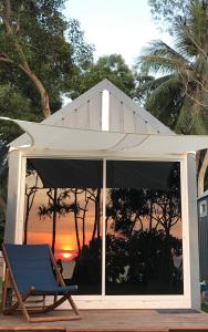 高兰Walden Koh Lanta - Tiny Homes by the Sea的一个带椅子和遮阳伞的甲板,享有日落美景
