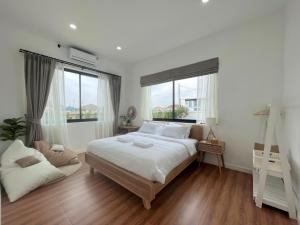 清莱373 pool villa的白色卧室设有大床和窗户