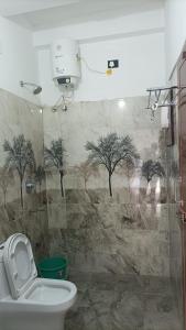 蓬蒂切里Tru Comfort的设有带卫生间的浴室,墙上有树木
