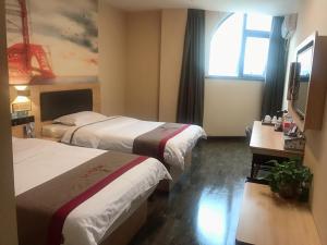 郑州尚客优酒店河南郑州新郑市中华北路轩辕湖店的酒店客房设有两张床和窗户。