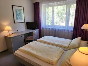 马瑟尔贝格Werrapark Resort Hotel Am Sommerberg的配有窗户的酒店客房内的两张床