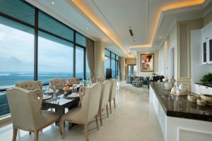 巴淡岛中心Panbil Residence Serviced Apartment的一间带桌椅和大窗户的用餐室