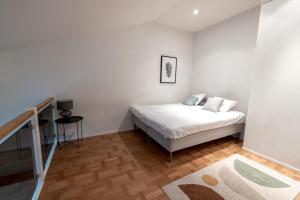 赫尔辛基2ndhomes Luminous & Modern 107m2 Penthouse in Kruununhaka的白色卧室配有床和桌子