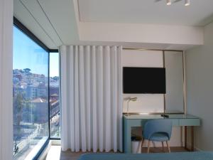 里斯本New Style Lisbon Hotel的一间卧室设有一张桌子和一个大窗户