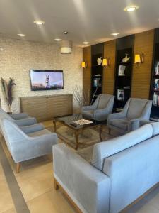 BulancakBasoglu Bulancak Hotel的带沙发的客厅和墙上的电视