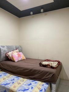 巴利盖Paima Homestay的壁旁的房间里一张睡床