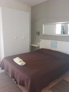 切萨雷奥港Cosy Residenze的一间卧室配有一张带棕色毯子的床