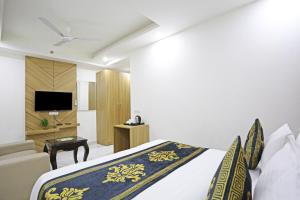 新德里Hotel Decent Suites - Delhi Airport的酒店客房,配有床和电视