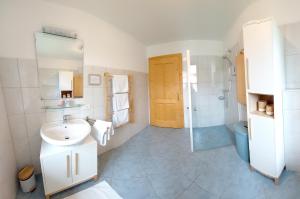 阿特湖威尔斯霍夫酒店的白色的浴室设有水槽和淋浴。