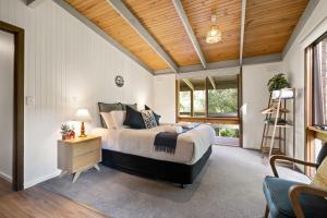 芒特比尤蒂吉瓦山林小屋的一间卧室设有一张床和木制天花板