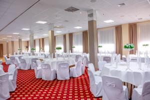 塔诺沃帕格涅500酒店的宴会厅配有白色的桌椅