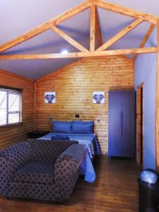 波罗瓜尼ZUCH Accommodation at Pafuri Self Catering - Guest Cabin的一间卧室配有一张床和一个沙发