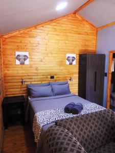 波罗瓜尼ZUCH Accommodation at Pafuri Self Catering - Guest Cabin的一间卧室设有一张床和木墙