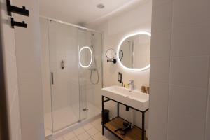 弗兰奎维尔-圣皮尔Logis Hôtel & Restaurant Le Vert Bocage的白色的浴室设有水槽和淋浴。