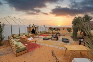 梅尔祖卡Golden Camp & Oasis的沙漠中的帐篷,配有长沙发和桌子