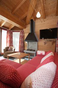 利莫内皮埃蒙特Chalets Mignon的客厅设有红色的沙发和壁炉