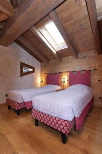 利莫内皮埃蒙特Chalets Mignon的配有木天花板的客房设有两张床。