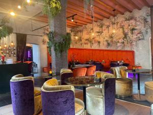 米德尔堡罗斯福精品酒店的一间餐厅,房间内设有紫色椅子和桌子