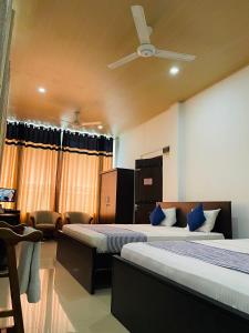 马特莱Ama Residence的酒店客房配有两张床和吊扇。