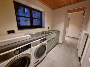 Lo-ReningeDe Bogaerd的厨房配有洗衣机和水槽