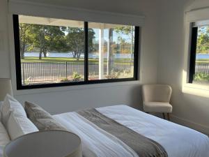 莱克斯恩特伦斯Skipper’s Lakes Entrance *Waterfront*的卧室配有白色的床和2扇窗户。