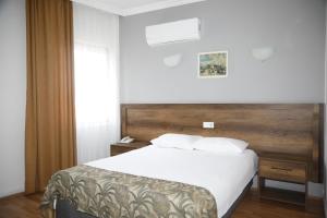 安卡拉Cihan Palas的卧室配有白色的床和木制床头板