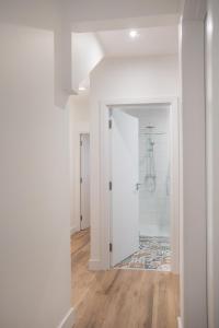 贝尔法斯特Central Avenue Apartment的走廊设有白色墙壁和木地板,浴室