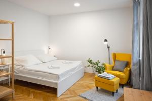 布拉格Prague 6 apartments的一间卧室配有一张床和一张黄色椅子