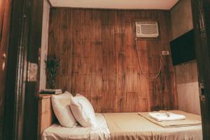 巴莱尔Casitas Stay and Surf的小房间设有一张木墙床
