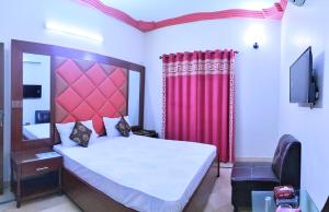 卡拉奇Subhan Palace Guest House的一间卧室配有一张大床和红色窗帘