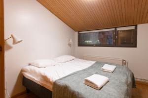 普哈圣山HolySuites 1 Ski-In & Ski-Out Holiday Home的一间卧室配有一张床,上面有两条毛巾