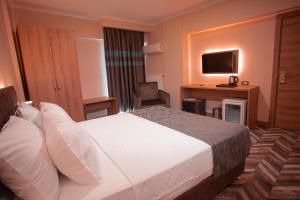 恰纳卡莱Hotel Kale 17的酒店客房,配有床和电视