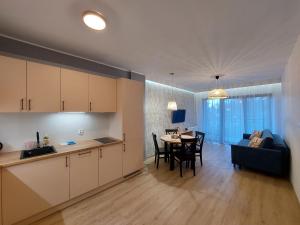 卡尔帕奇Apartament Pod Papugami 2 Karpatia Resort的厨房以及带桌子和沙发的客厅。