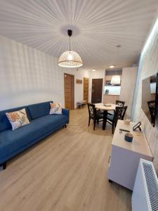 卡尔帕奇Apartament Pod Papugami 2 Karpatia Resort的客厅配有蓝色的沙发和桌子