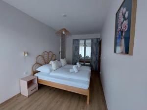 卡尔帕奇Apartament Pod Papugami 2 Karpatia Resort的一间卧室配有一张带白色床单的大床