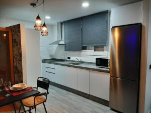 乌夫里克Apartamento Sierra Lof Paraiso的厨房配有桌子和不锈钢冰箱。