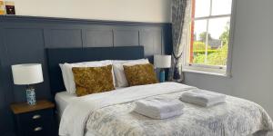 布兰德福德福鲁姆Portman Lodge的一间卧室配有带毛巾的床