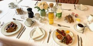 布兰德福德福鲁姆Portman Lodge的一张白色的桌子,上面放着早餐盘