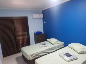 伯迪亚哥Apartamento Duplex pé na areia em Boracéia的蓝色墙壁客房的两张床