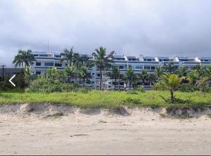 伯迪亚哥Apartamento Duplex pé na areia em Boracéia的海滩前一座棕榈树大建筑
