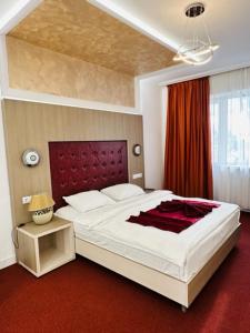 斯拉蒂纳布鲁瓦德名望酒店的一间卧室配有一张大床和红地毯