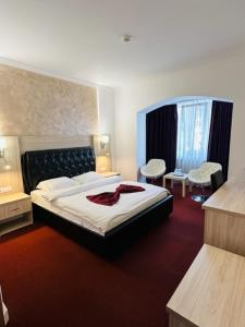 斯拉蒂纳布鲁瓦德名望酒店的酒店客房,配有一张床和两把椅子